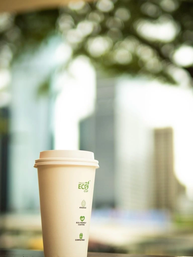 A retail-ready compostable toothpaste tube photographed as a printed specimen on raw paper.