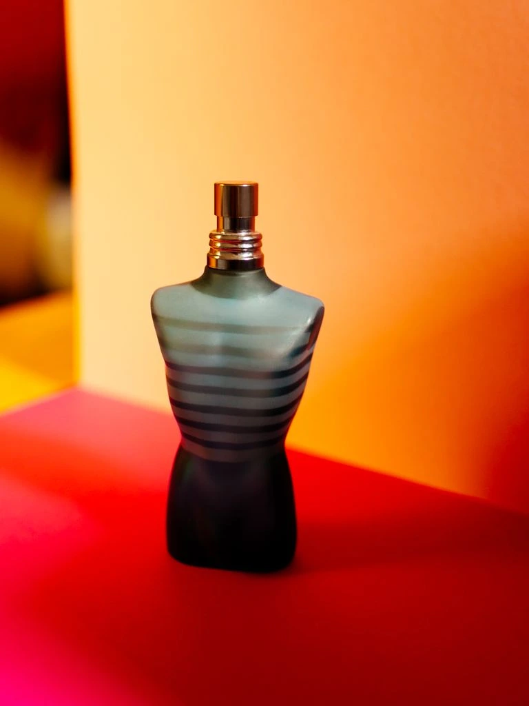 Glass beverage bottle with paper label on cream paper.